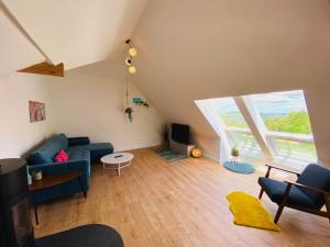 a living room with a blue couch and a large window at Auszeit-Eifel „Eifelhorst“ in Willwerscheid