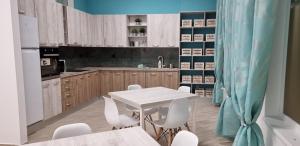 a kitchen with a white table and white chairs at HOSTEL CITADELLA in Deva