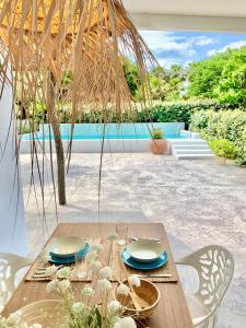 un tavolo in legno con piatti e sedie su un patio di Villa Nature con Piscina Privada · Wifi ·AC · BBQ a Blanes