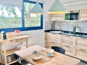 cocina con mesa y sillas y cocina con toques azules en Villa Nature con Piscina Privada · Wifi ·AC · BBQ en Blanes