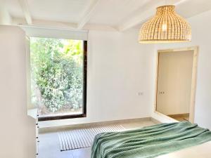 ein Schlafzimmer mit einem Bett und einem Fenster in der Unterkunft Villa Nature con Piscina Privada · Wifi ·AC · BBQ in Blanes