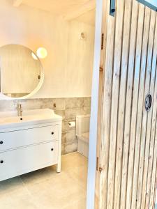 a bathroom with a white sink and a mirror at Villa Nature con Piscina Privada · Wifi ·AC · BBQ in Blanes