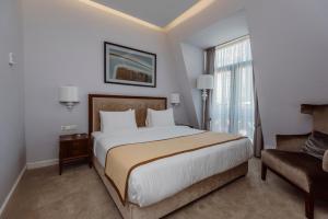巴統的住宿－巴統黃金宮賭場和酒店，一间卧室设有一张大床和一个窗户。