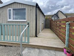 a wooden ramp leading to a house with a fence at Kevara Shepherds Hut in Finstown