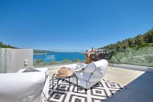 阿洛尼索斯古镇Eleon Suites new的带桌椅的阳台，可欣赏水景