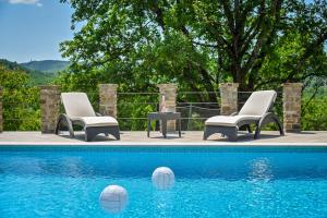 2 sillas y una mesa junto a la piscina en Villa Brbon, en Krbune