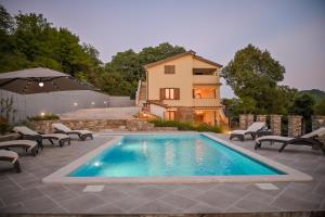 una piscina con sillas y una casa en el fondo en Villa Brbon, en Krbune