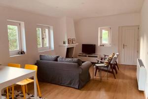 a living room with a couch and a table and chairs at Casa do Rio. Sossego à beira rio. in Rio de Onor