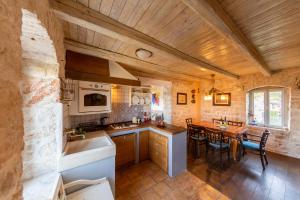 a kitchen and dining room with a wooden ceiling at Golden Summerhouse in Komiža