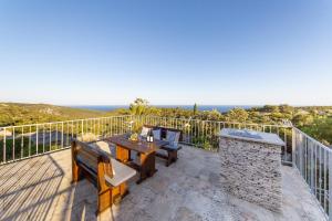 a patio with a table and chairs and the ocean at Golden Summerhouse in Komiža