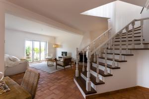 a living room with a staircase in a house at Villa Octopus's Garden by ACasaDasCasas in Santo Isidoro