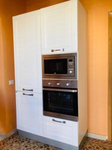 uma cozinha com armários brancos e um micro-ondas em LA CONCHIGLIA em Marsala
