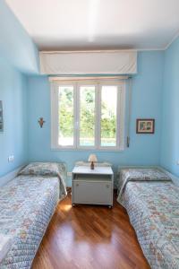 two beds in a room with blue walls and a window at Appartamento a Rapallo a 100 mt dalla spiaggia in Rapallo