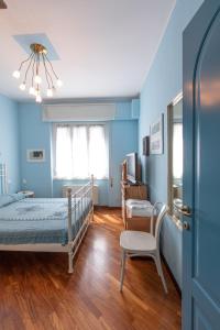 una camera da letto con pareti blu e un letto e una sedia di Appartamento a Rapallo a 100 mt dalla spiaggia a Rapallo