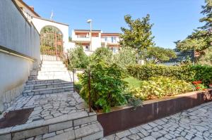 einen Garten mit Pflanzen und Treppen vor einem Gebäude in der Unterkunft Apartment in Pula with Two-Bedrooms 3 in Pula