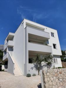 a white house with stairs on the side of it at Apartman Karmen in Tučepi