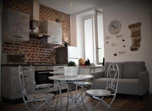 uma cozinha com uma mesa e cadeiras e um sofá em Rial Maison em Bérgamo