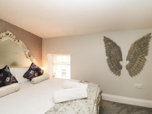 a bedroom with a bed with wings on the wall at Corner Cottage Stanhope Castle in Bishop Auckland