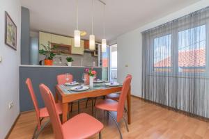 a dining room with a table and red chairs at Apartment Josipa in Omiš