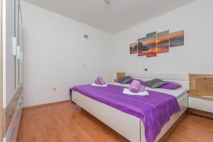 a bedroom with a large bed with purple sheets at Apartment Josipa in Omiš