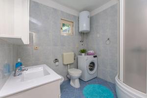 a bathroom with a sink and a washing machine at Apartment Josipa in Omiš