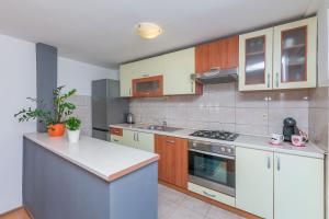 a kitchen with white counters and wooden cabinets at Apartment Josipa in Omiš