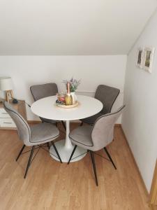 un tavolo bianco con sedie in una stanza di DreamView a Brodarica