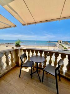 un tavolo e sedie su un balcone con vista sulla spiaggia di Sea view apartment a San Vincenzo