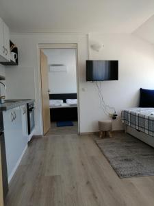 a small room with a bed and a kitchen and a room with a kitchen at Apartment Happy 3 in Pakoštane