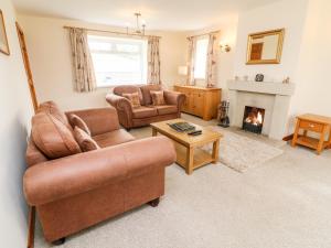 uma sala de estar com dois sofás e uma lareira em Jess Cottage em Skipton