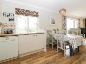 a kitchen and dining room with a table and chairs at Meadowlea Cottage in Plymouth