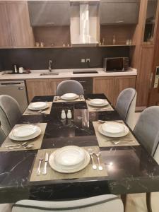 stół z talerzami i przyborami kuchennymi w kuchni w obiekcie Sarwat Park Hotel w mieście Abha