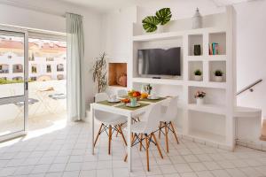 a white dining room with a table and chairs at Apartments in Albufeira - Old Town in Albufeira