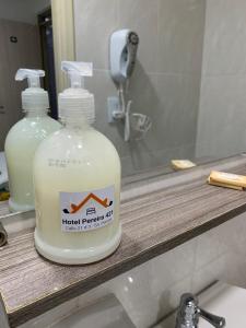 a bottle of hand soap sitting on a bathroom sink at Hotel Pereira 421 in Pereira
