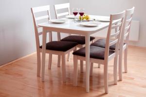 - une table à manger blanche avec 4 chaises et des verres à vin dans l'établissement Apartments Marta, à Žabljak