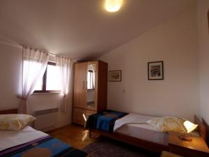 een kleine slaapkamer met 2 bedden en een raam bij Apartment in Kožino with sea view, balcony, air conditioning, WiFi (4262-1) in Kožino