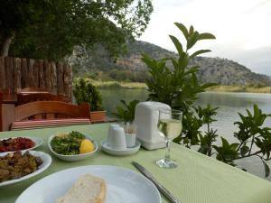 a table with a plate of food and a glass of wine at Dalyan Pension in Dalyan