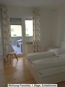 1 dormitorio con 1 cama, 1 silla y 1 ventana en Ferienwohnung im Herzen der Koblenzer Altstadt, en Coblenza