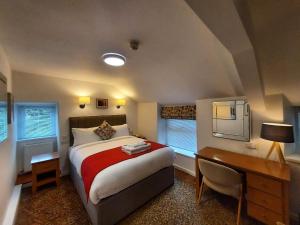 a bedroom with a bed and a desk and a desk at Richmond Hotel in Aberystwyth +107 photos