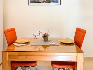 Green Home Apartments في كوتور: طاولة خشبية عليها كرسيين ومصنع