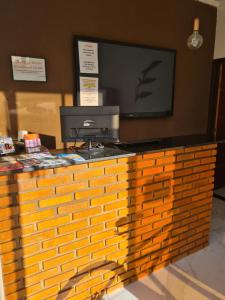 a wooden counter with a television on top of it at Pousada Canto dos Corais in Maragogi