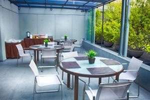 a restaurant with tables and chairs and windows at Suites Aura For Living in Mexico City