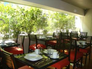 a restaurant with tables and chairs and a large window at Suites Aura For Living in Mexico City