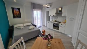 um quarto com uma cama e uma mesa numa cozinha em Alberira Apartments em Palermo