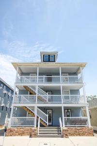 a large white house with stairs in front of it at Garfield Beach House in Wildwood