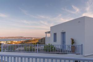 a white house with a balcony with a view of the ocean at Milesian Suites in Adamantas