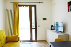 a living room with a yellow couch and a television at LA PIGNA mare, collina, Ravenna, Mirabilandia, Cottignola in Ghibullo