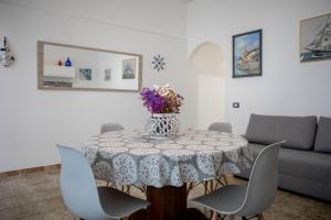 - une table à manger avec un vase de fleurs dans l'établissement Appartamenti Via Tecchi, à Porto Cesareo