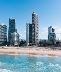 a city with tall buildings and palm trees at Rhapsody Resort - Official in Gold Coast