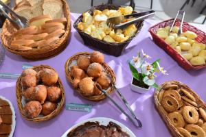 een paarse tafel met manden met eten en brood bij Vinds Economic Hotel in Ipatinga